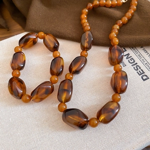 Detailed view of amber acrylic beaded necklace on vintage background with soft lighting