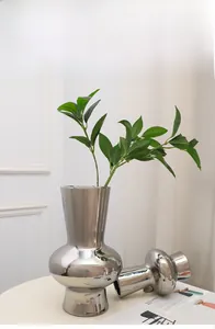 Modern silver ceramic vase set with mirror finish and green plants for home decor