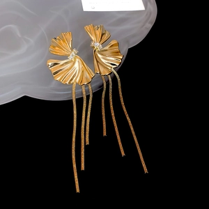 Detail of gold ginkgo leaf earrings with long metal tassels and zircon inlay decoration