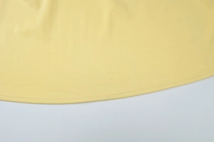 Dettaglio dell'abito estivo giallo con cucitura professionale a doppio ago sull'orlo
