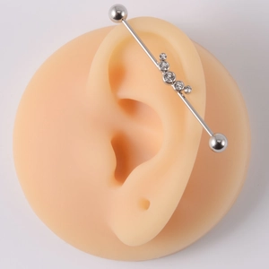 Detail showing high-quality stainless steel industrial barbell with clear gems on ear model