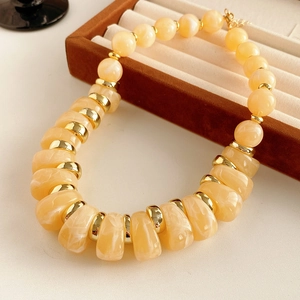 Détail d'un collier vintage avec perles couleur ambre et intercalaires en métal doré