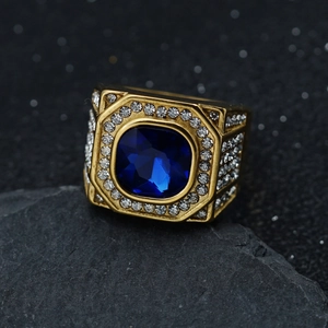 Macro shot of gold men's ring with a large blue square stone and white pavé zircons