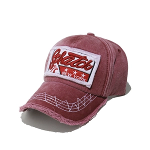 Detail of vintage washed baseball cap with embroidered New York patch and frayed brim