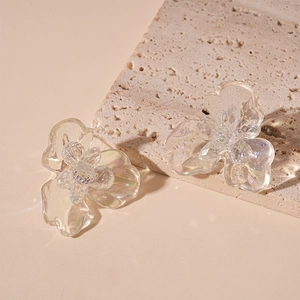 Detailed macro view of clear resin flower earrings with shimmering crystal stamen beads