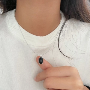 Detailed close-up of a S925 silver necklace featuring a black oval agate pendant on skin