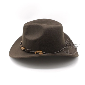 Detail view of a brown wide brim cowboy hat with woven cord and ethnic beaded accents