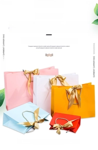 Colorful paper gift bags with woven handles and shiny gold satin ribbons in various colors
