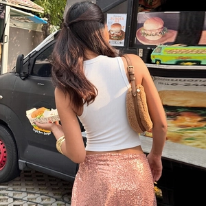 Photo de rue d'un débardeur blanc sans manches associé à une jupe à paillettes roses