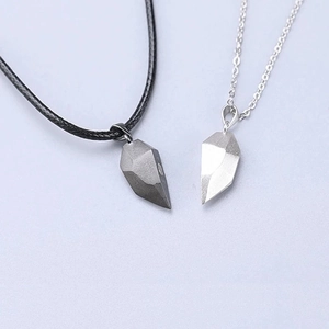 Close-up of magnetic matching heart necklaces with geometric pendants for couples