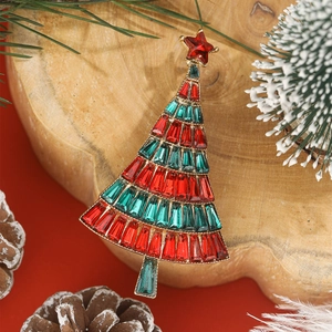 Macro detail of Christmas tree brooch with red and green stones on pine cone background