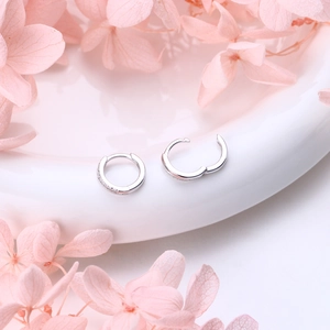 Détail des boucles d'oreilles créoles en argent avec micro-pavage de zircons étincelants