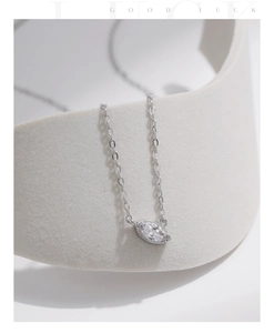Detail of silver S925 necklace with a marquise-cut zircon pendant on white curved prop