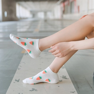Detail of white cotton low cut socks with red strawberry pattern and elastic cuff