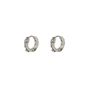 Gros plan sur des boucles d'oreilles cœur géométriques en argent avec cristaux brillants