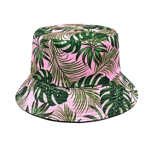 Detail of pink cotton bucket hat with dark green tropical palm and monstera leaf print