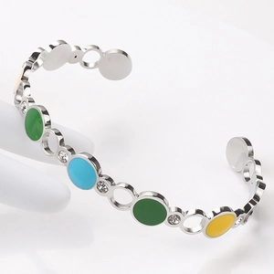 Detail of colorful enamel inlay and crystal studs on a silver C-shaped stainless bangle