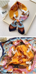 Macro detail of the silk-textured scarf showing elegant deer and floral art print