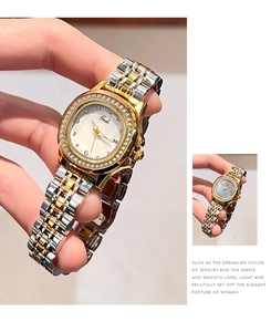 Detail of two-tone steel watch with crystal bezel, date window, and mother of pearl dial
