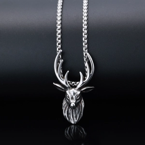 Macro shot of stainless steel stag head pendant with box chain on black background