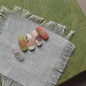 Artistic Japanese style press-on nails featuring green, beige, and grid patterns on linen