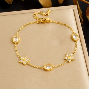 Detail of gold-plated stainless steel flower bracelet with white zircons and lobster clasp