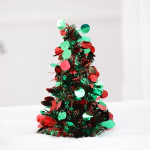Macro shot of small red and green sequined Christmas tree desk ornament on white background