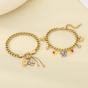 Golden NK chain bracelet featuring butterfly, clover, and square pendants with zircon crystals