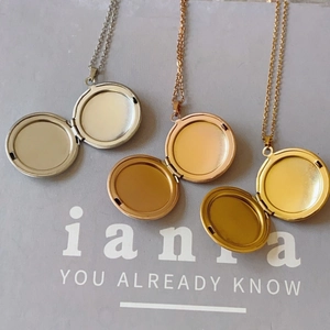 Three-color round locket necklaces in gold, rose gold, and silver finishes on a display box