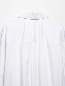 Detailed back view of white cotton blouse showing horizontal yoke and box pleat design