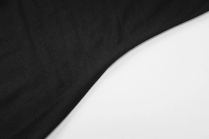 Close-up detail of soft black cotton knit fabric texture with fine uniform weave