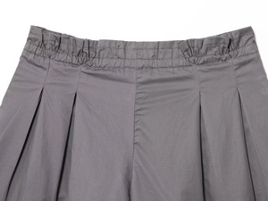 Detailed macro view of the elastic waistband and pleated texture on grey poplin shorts