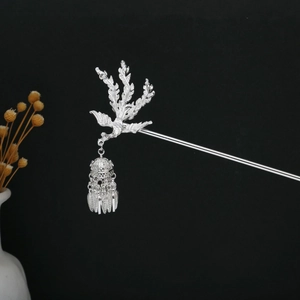 Detail view of silver phoenix hair pin with hollow lantern pendant and metallic tassels