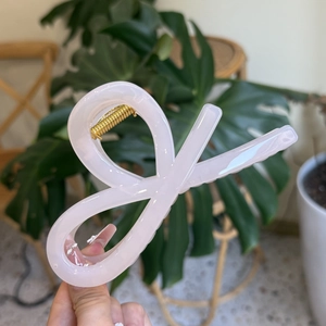 Pink bow knot claw clip made of acetate with a high-gloss finish and golden metal spring