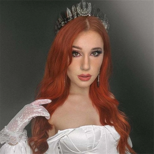 Detail of female model wearing black crystal moon crown with white lace gloves