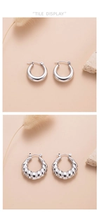 Detail display of smooth silver hoop earrings and textured wavy metal ring earrings