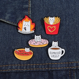 Detail of five cute cat food enamel pins on denim, featuring donut and fries designs