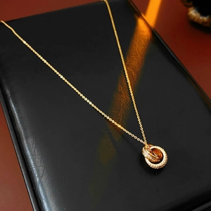 Detail of 18K gold plated triple interlocking circles necklace with micro-pave zircons