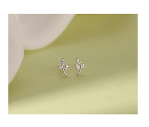 Macro detail of silver leaf stud earrings with sparkling pavé zircons in a nature design