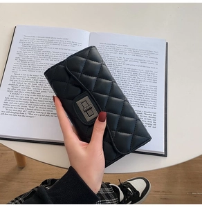 Detailed view of black quilted long wallet with vintage bronze metal twist-lock clasp