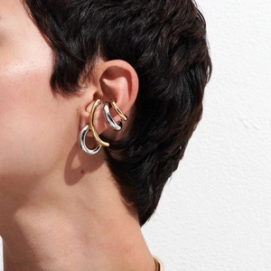 Close-up of model wearing gold and silver stainless steel ear cuffs and stud earrings