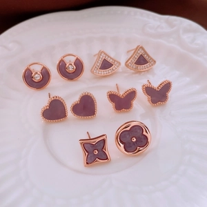 Detail showing five rose gold stud earrings with purple enamel and zircon inlay designs