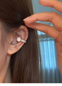 Close-up of a silver zircon ear cuff featuring a large round stone and pavé setting