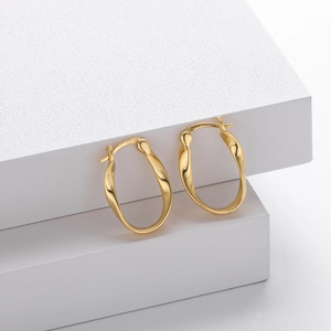 Detail shot of golden S925 sterling silver Mobius twisted earrings on geometric stand