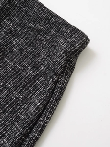 Dettaglio macro della trama in maglia tweed grigio scuro per completo pantalone