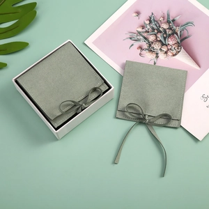 Detailed view of sage green velvet jewelry pouch with bow tie and matching gift box
