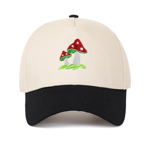 Close-up of mushroom embroidery detail on two-tone canvas trucker hat with black brim