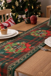 Detail of Christmas table runner with wreath and plaid pattern on wooden table