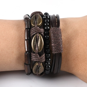 Close-up of four-piece vintage layered leather bracelets with shell pendant and wooden beads