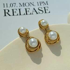 Elegant gold textured double pearl drop earrings for women on a minimalist beige display